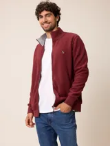 Campera de polar bordó con cierre frontal completo, cuello alto y puños elásticos. Presenta un diseño liso con logo bordado en el pecho.