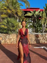 Vestido largo de fiesta color fucsia con degradé a morado, con escote drapeado profundo, espalda descubierta y abertura alta en la pierna. Ajustado en la cintura y con breteles finos.