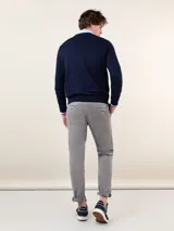Pantalón chino azul marino de corte slim fit, confeccionado en gabardina con 77% algodón, 20% de algodón reciclado y 3% elastano. Presenta bolsillos delanteros y traseros. Tiene un lavado final con enzima ácida que le da un aspecto desgastado.