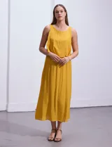 Vestido largo color mostaza, sin mangas, con escote redondo y detalle de crochet en los hombros.