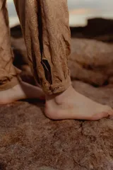 Pantalón babucha color ocre con estampado de flores pequeñas, corte holgado y cintura elástica.