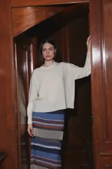 Sweater de punto color crudo, con cuello redondo, manga larga y corte holgado.