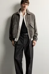 Cazadora de hombre regular fit confeccionada en tejido efecto ante, con acabado lavado, cuello solapa, manga larga, bolsillos de plastrón con solapa en la cadera, detalles elásticos en puños y cintura, y cierre frontal de cremallera.