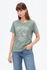 Remera de manga corta color verde militar, con cuello redondo y diseño holgado. Presenta estampado frontal con ositos y texto con detalles de glitter.