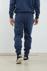 Pantalón jogging de corte ajustado, con cintura elástica y puños elastizados en los tobillos. Presenta un diseño minimalista en color gris oscuro, ideal para un look urbano y deportivo.