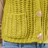 Chaleco de punto color verde oliva, sin mangas, con cuello redondo y cierre frontal con botones grandes dorados.