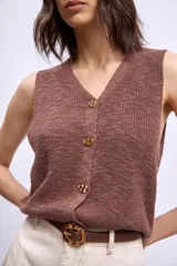 Chaleco de punto color marrón, con escote en V y cierre frontal con botones dorados.