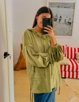 Buzo tipo hoodie oversize confeccionado en plush, con capucha, cordones ajustables y bolsillo frontal tipo canguro. Presenta puños elásticos y logo bordado en el pecho.