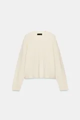 Jersey de punto de tacto suave color blanco, con cuello redondo, mangas largas y puños y bajo de canalé.
