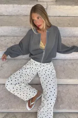 Chaqueta bomber de punto color beige con brillo sutil, cuello redondo, mangas largas abullonadas y cierre frontal de cremallera metálica.