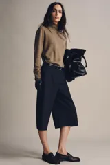 Bermuda larga de tiro medio, color azul marino con finas rayas diplomáticas blancas. Presenta cintura con trabillas, bolsillos laterales ocultos en costura y cierre frontal con cremallera, botón y ganchos metálicos.