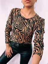 Remera de manga larga con cuello redondo y estampado de cebra en colores verde, rojo, azul y marrón.