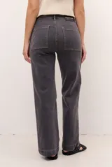 Jeans de corte recto y tiro medio color gris oscuro, con costuras en contraste y detalles de bordado geométrico en el bajo.