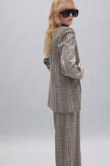 Blazer de cuello solapa y manga larga con diseño de cuadros. Presenta cierre frontal cruzado con botones.