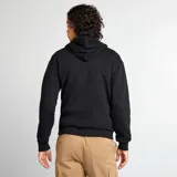 Buzo de chándal negro con capucha ajustable mediante cordones, bolsillo canguro frontal y etiqueta blanca en el dobladillo.
