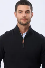 Buzo de tejido fino en hilo de algodón, color rosado, con cuello alto y cierre frontal parcial con detalle en cuero. Presenta puños y ruedo acanalados y un pequeño logo bordado en el pecho.