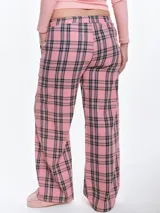 Pantalón de dormir de franela de algodón con estampado de cuadros escoceses en tonos rojos, negros y blancos. Presenta un corte recto y holgado, cintura elástica con cordón ajustable y bolsillos laterales.