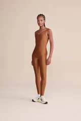 Jumpsuit largo de diseño ajustado con escote redondo y espalda descubierta. Confeccionado en tejido satinado con textura acanalada y tecnología de compresión media.