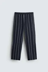 Pantalón de corte relajado, color azul marino, con rayas verticales blancas finas. Presenta cintura elástica ajustable con cordón interior y bolsillos laterales y traseros de plastrón.