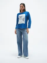 Blusa azul con estampado abstracto en blanco y negro, de mangas largas.