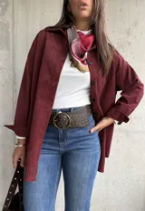 Sobrecamisa de pana color bordó, con cuello camisero, cierre frontal de botones y mangas largas con puños. Presenta una textura acanalada característica de la pana.