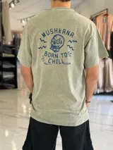 Remera oversize de manga corta en color verde militar con efecto gastado, con estampado gráfico en la espalda que incluye una calavera y la frase "Born to Chill".