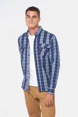 Camisa de franela a cuadros azul y blanco, de manga larga, con dos bolsillos frontales con solapa abotonada.