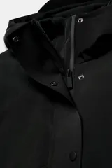 Chaqueta acolchada de corte corto con cuello subido y capucha. Presenta cierre frontal con cremallera termosellada y solapa con botones a presión, bolsillos laterales con cierre, mangas largas con puños elásticos y bajo ajustable con cordones.