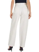 Jean blanco de corte amplio, talle alto y estilo balloon, con efecto desgastado en las rodillas y ruedo desflecado.