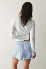 Pack de dos shorts de pijama con cintura elástica, cordón ajustable y aberturas laterales en el dobladillo. Uno presenta diseño a rayas celestes y blancas, y el otro diseño a rayas blancas y celestes.