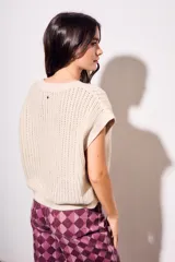 Chaleco de punto con textura acanalada y acabado brillante, de corte holgado, cuello redondo y mangas cortas estilo sisa.