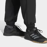 Pantalón deportivo Adidas Designed For Training Warm-Up color negro, con ajuste holgado, cintura elástica con cordón, bolsillos frontales con cierre, puños elásticos y tecnología Climacool.