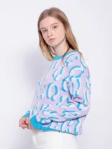 Sweater de punto amarillo con estampado animal print rosa, de manga larga y cuello redondo.