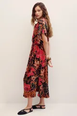 Vestido midi de viscosa con estampado floral en tonos rojos, naranjas y negros sobre base oscura. Cuenta con mangas cortas amplias, escote en V con cuello tipo camisero y cierre frontal de botones.