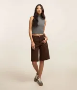 Blusa sin mangas de cuello alto, confeccionada en tejido rib acanalado de color gris. Presenta un diseño ajustado al cuerpo y estilo minimalista.