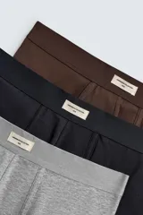 Pack de tres bóxers de hombre en colores gris melange, negro y marrón oscuro, confeccionados en tejido elástico con acabado aterciopelado y cintura elástica.