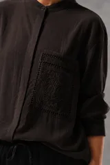Camisa de lino color crudo con bolsillo frontal cuadrado destacado con bordado richelieu y diseño geométrico floral.