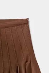 Falda midi marrón de tiro alto con pliegues marcados en la parte superior que caen en un vuelo amplio.