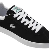 Championes Lacoste modelo Baseshot, de diseño urbano y perfil bajo. Confeccionados en gamuza color azul marino, presentan cordones blancos, suela de goma blanca y el logo del cocodrilo bordado en el lateral con la inscripción EST. 1933.