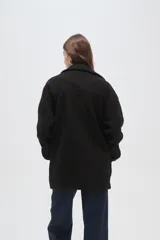 Tapado de lana con diseño a cuadros en tonos marrones y beige, de corte holgado, con cuello de solapa y cierre frontal con botones.