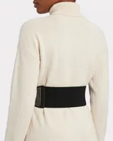 Cinto ancho tipo faja, color negro, confeccionado en material elástico con múltiples filas de tachas metálicas en los laterales.