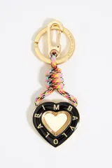 Llavero con dije en forma de corazón de metal esmaltado en negro con el logo de la marca grabado en el borde y centro dorado. Incluye un cordón trenzado multicolor y herrajes metálicos en tono dorado.