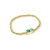 Pulsera elástica de cuentas doradas con dije central de ojo turco con borde dorado.