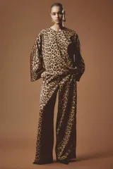 Blusa de corte holgado con estampado animal print de leopardo, escote redondo, mangas largas amplias y diseño recto.