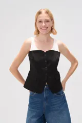 Top negro con breteles anchos, escote recto, cierre frontal con botones y bolsillos tipo parche.