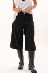 Bermuda de tiro medio y silueta amplia, confeccionada en tela negra. Cuenta con bolsillos delanteros y traseros, cierre frontal con cremallera y botón.