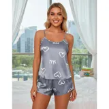 Conjunto de pijama de dos piezas compuesto por una musculosa de tirantes finos y un short, confeccionado en satén con acabado brillante. Presenta un estampado de corazones y figuras abstractas en color blanco sobre una base azul marino.