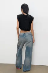 Top de algodón con cuello redondo, diseño sin mangas con hombreras marcadas y detalle de pliegues. Presenta un bajo acabado tipo globo con elástico.
