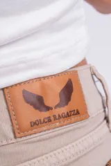 Pantalón mom jean color beige, de tiro alto, con bolsillos delanteros y traseros, y ruedo doblado.