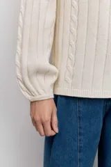 Sweater de tejido de punto color bordó, con cuello alto, mangas largas con puños ajustados y diseño de trenzas verticales.